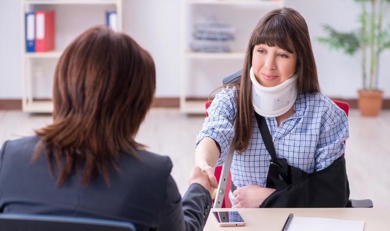 An injured woman meeting with a lawyer.