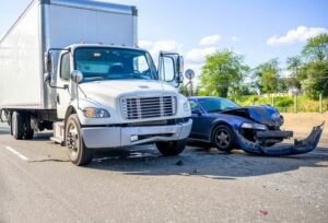 Image is of a vehicle accident scene involving a semi truck and car concept of a Marietta truck accident lawyer