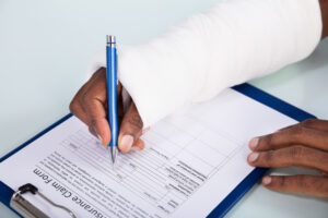 Workers' Compensation Lawyer Charlotte, NC - Injured Man Filling Insurance Claim Form