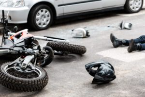 Rider and motorcycle lying on the ground after a crash before calling a Hickory Motorcycle Accident Lawyer