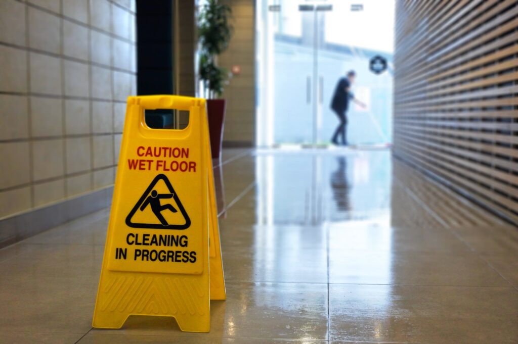 Hallway with a yellow caution wet floor sign in the middle
