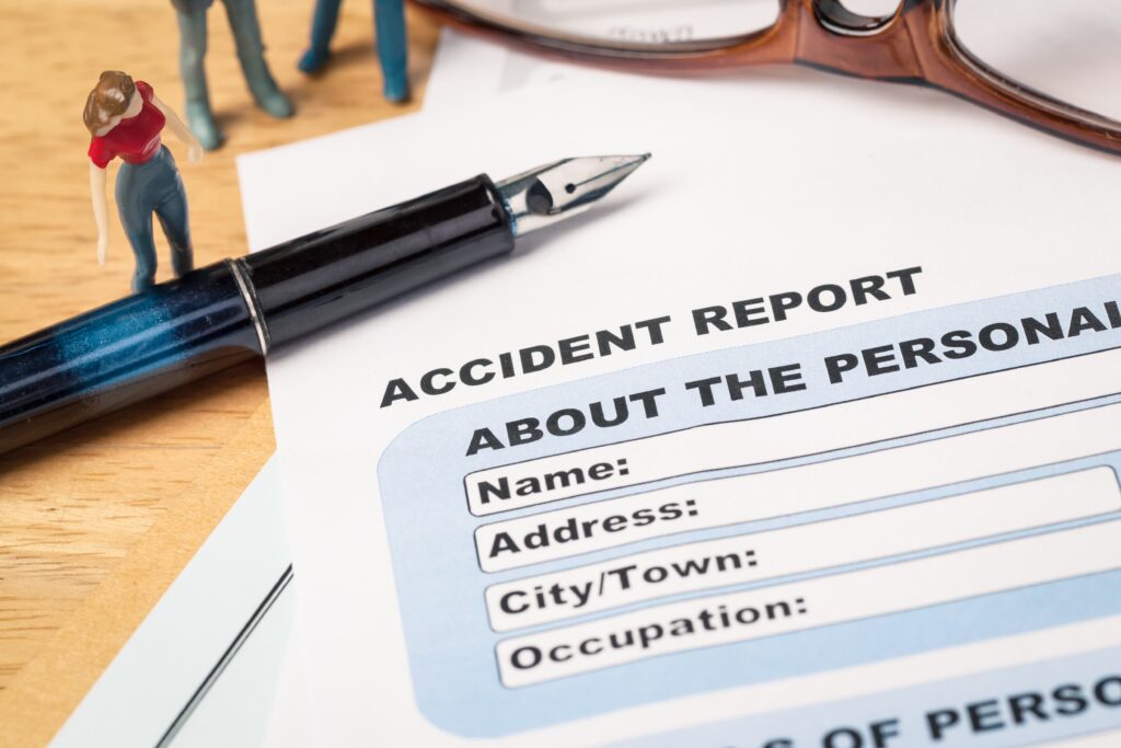 Accident report document with a pen laying across the paper